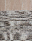 Trendy Dahlia Beige Handmade Wool Rug, showcasing intricate floral patterns in soft beige tones, hand-knotted wool construction brings warmth and texture to a well-lit living space.