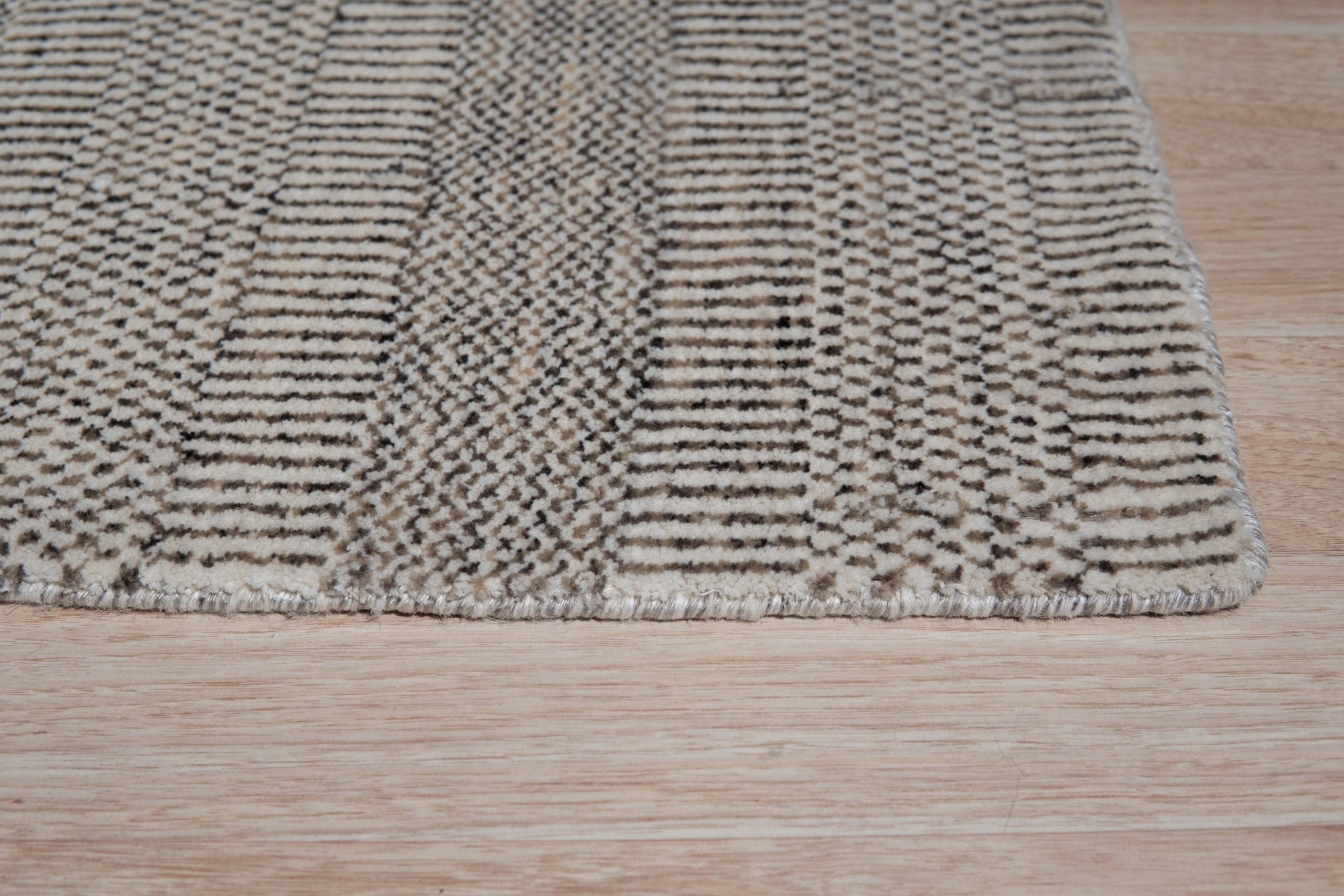Trendy Dahlia Beige Handmade Wool Rug, a neutral expanse with subtle dahlia floral patterns, lending warmth and texture to a modern living space.