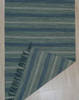 Chic Striped Turquoise Flatweave Wool & Bamboo Silk Rug, displaying its vibrant turquoise stripes contrasting with natural wool tones in a contemporary setting.