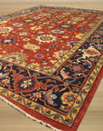 Kira Zinnia Rust Hand Knotted Wool Rug displayed in a living room setting. Warm rust tones and a floral zinnia pattern bring a touch of nature indoors. Hand-knotted wool construction adds texture and visual depth to the space.