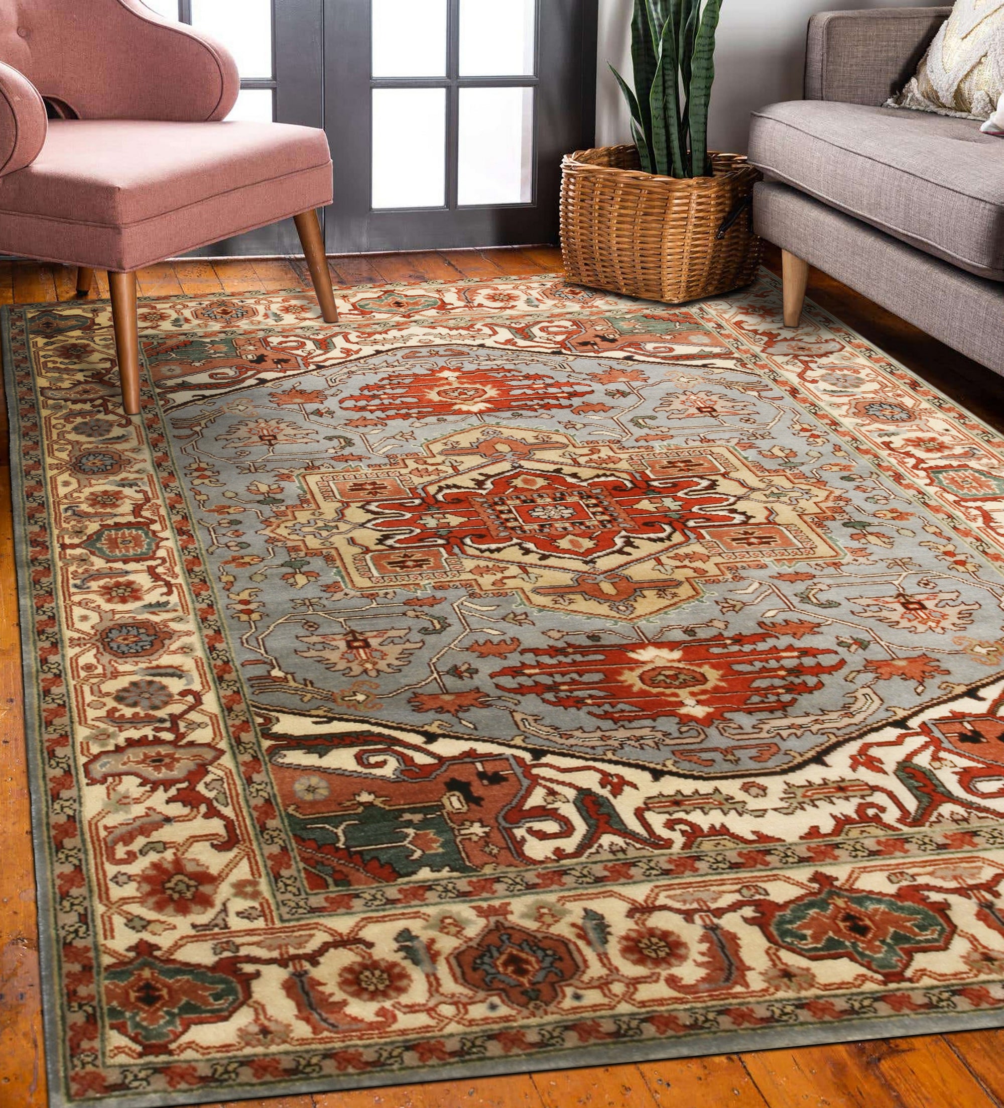 Amara Ruby Blue Hand Knotted Wool Rug displayed on a light hardwood floor, its ruby red and blue hues creating a vibrant contrast. Intricate hand-knotted construction evident in the rug's texture.