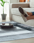 Sophie Gabbeh Gray Handmade Wool Rug, featuring a subtly textured gray field and simple, rustic design, lays elegantly on a hardwood floor, illuminated by natural light.