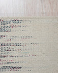Brenda Refined Multicolor Flatweave Wool Rug, showcasing vibrant hues and a geometric pattern, lies flat on a hardwood floor, its texture suggesting soft wool construction.