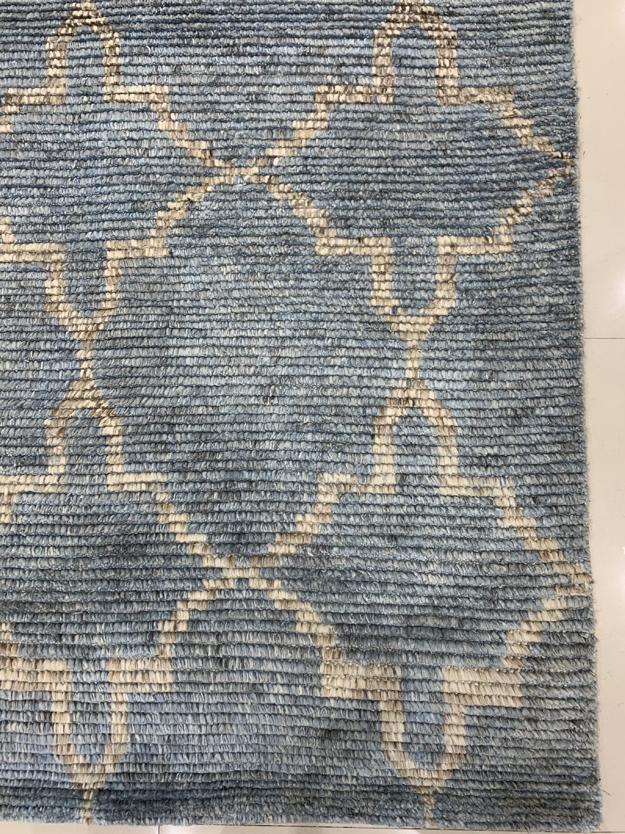 Versatile Agra Blue Hand Knotted Wool Rug, its intricate, geometric patterns in shades of blue and cream bringing an elegant touch to a light-filled living space.