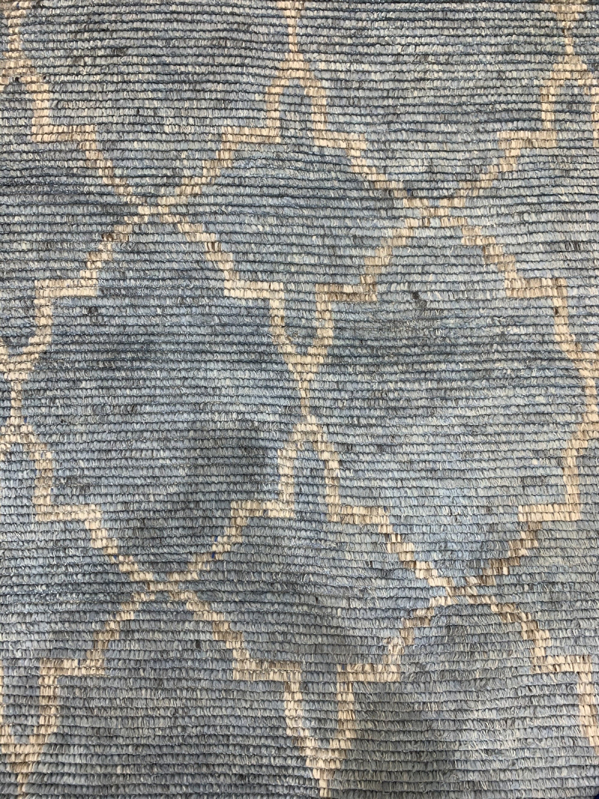 Versatile Agra Blue Hand Knotted Wool Rug, showcasing a detailed, traditional pattern in shades of blue against a lighter backdrop, possibly wool, with intricate knotwork indicating hand-knotted construction, seen in a product-focused setting.