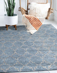 Versatile Agra Blue Hand Knotted Wool Rug, its intricate floral pattern in shades of blue and cream graces a light hardwood floor, inviting warmth and traditional elegance into the living space.