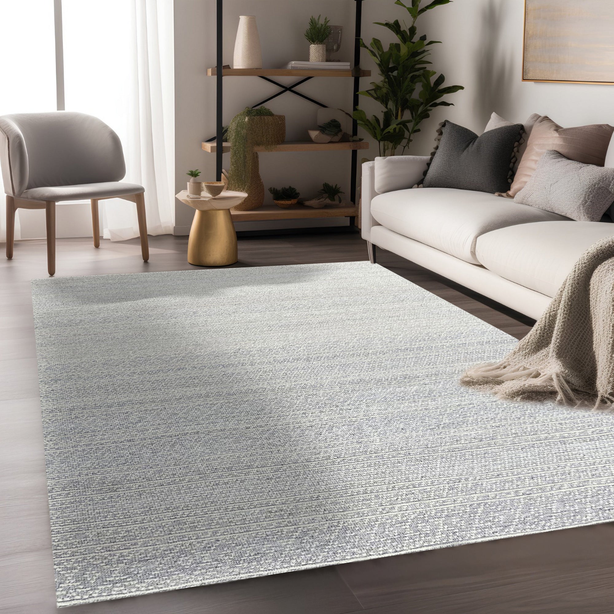 Bianca Louie Ivory Handmade Wool Rug, seen in a styled room setting, showcases its luxurious texture and subtle pattern under a modern coffee table with decorative books and objects. The soft ivory tones and hand-knotted wool construction create a warm and inviting atmosphere.