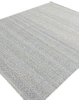 Bianca Louie Ivory Handmade Wool Rug layered beneath a light wood coffee table, styled in a bright, airy living room. The rug's soft ivory tones and subtle textural details complement the minimalist décor.