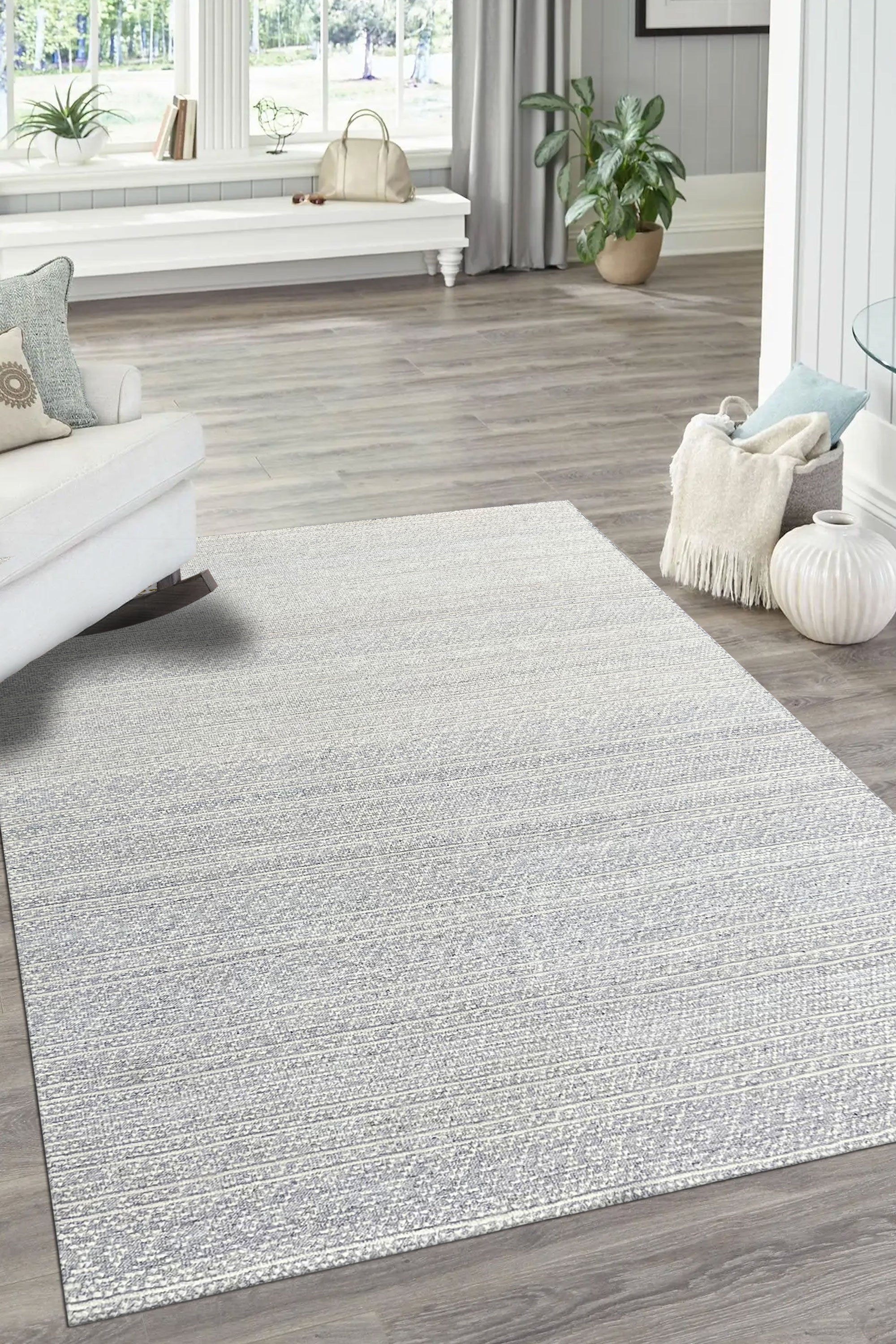 Bianca Louie Ivory Handmade Wool Rug, soft texture and intricate pattern detail visible under warm, inviting light; a testament to its handcrafted construction.