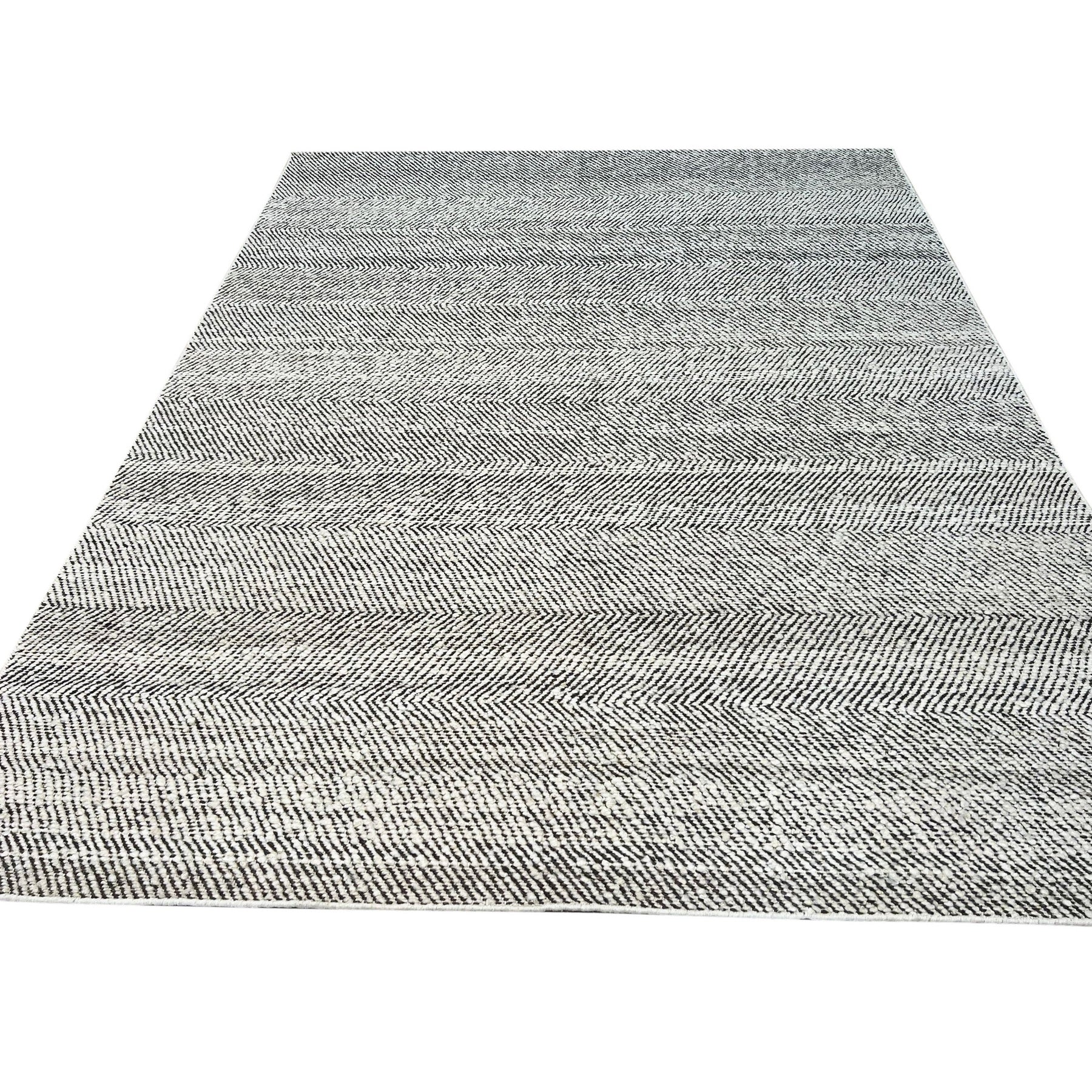 Louie Harlow White Handmade Wool Rug, blending seamlessly with a light-filled living room; its plush white wool texture inviting comfort and highlighting subtle design nuances within the surrounding neutral décor.