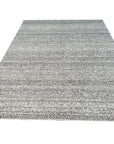 Louie Harlow White Handmade Wool Rug, blending seamlessly with a light-filled living room; its plush white wool texture inviting comfort and highlighting subtle design nuances within the surrounding neutral décor.