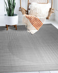 Majestic Chic Charcoal Handmade Wool Rug, charcoal wool rug displaying subtle tonal variations and texture, presented in a living room setting with modern furniture.