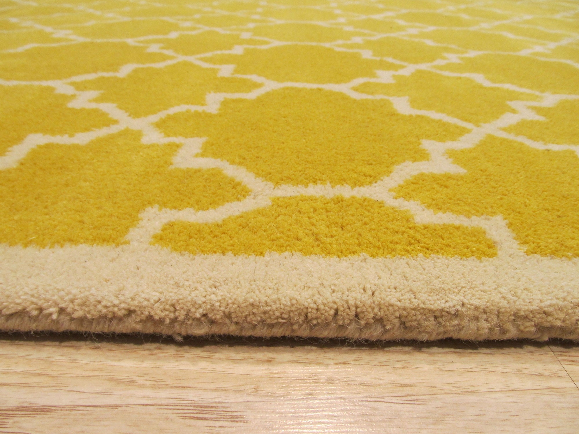 Enchanting Vibrant Yellow Hand Tufted Wool Rug, a sunny, textured statement piece, adds warmth to a bright, modern living room with natural wood accents.
