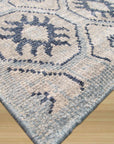 Para Giselle Blue Hand Knotted Rug, its intricate pattern of swirling blues and creams lies gracefully on a light hardwood floor, casting a serene and inviting atmosphere in the room.