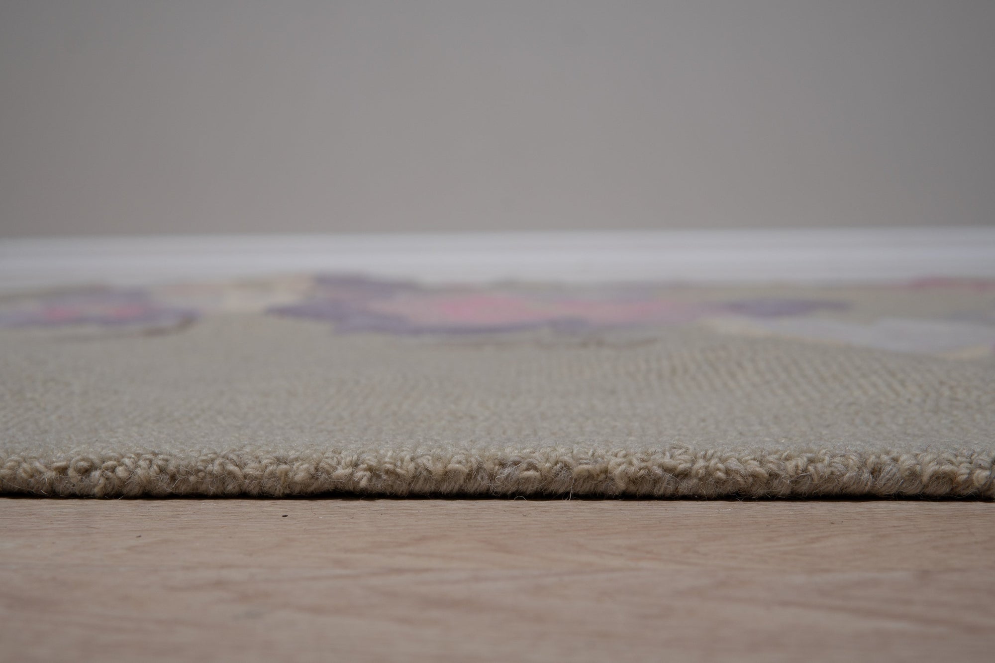 Rustic Elena Gray Hand Tufted Wool Rug, its textured gray wool lending a cozy ambiance to a warmly lit living room setting.