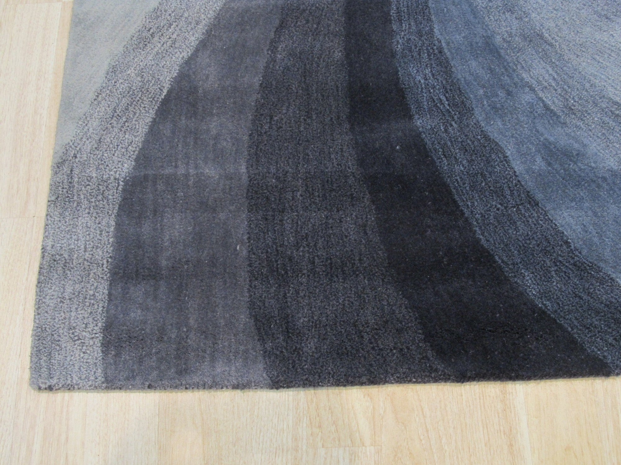 Stylish Timeless Blue Hand Tufted Wool Rug, showcases a textured blue field detailed with subtle variations, hand-tufted wool pile adding depth and warmth to the setting.