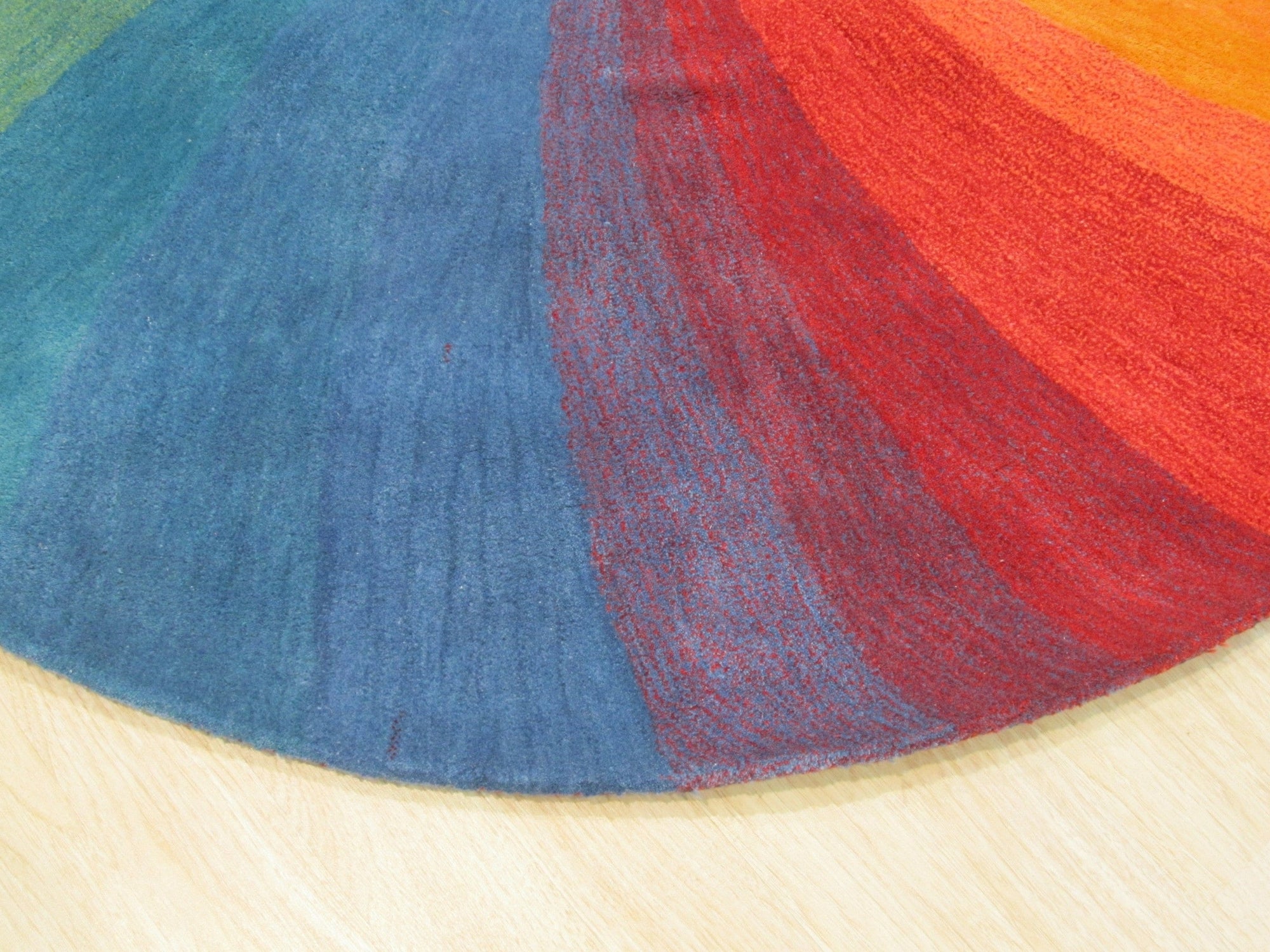 Talia Classic Rainbow Hand Tufted Wool Rug, vibrant arc of rainbow hues radiating across a plush, hand-tufted wool pile, illuminating a cozy interior setting.