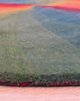 Talia Classic Rainbow Hand Tufted Wool Rug, bursts with vibrant hues in a contemporary living room setting. Wool construction showcases a dense, plush pile. Rainbow stripes cascade across the rug, adding playful energy to the space.