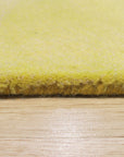 Brenda Chic Yellow Hand Tufted Wool Rug, a vibrant yellow wool rug hand-tufted with a chic, possibly geometric, design, warms a well-lit living space with a mid-century modern aesthetic.