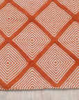 Refined Luxurious Orange Handmade Wool Rug, rich ochre tones swirling in a dense wool pile, hints of geometric pattern suggesting a timeless, handcrafted artistry.