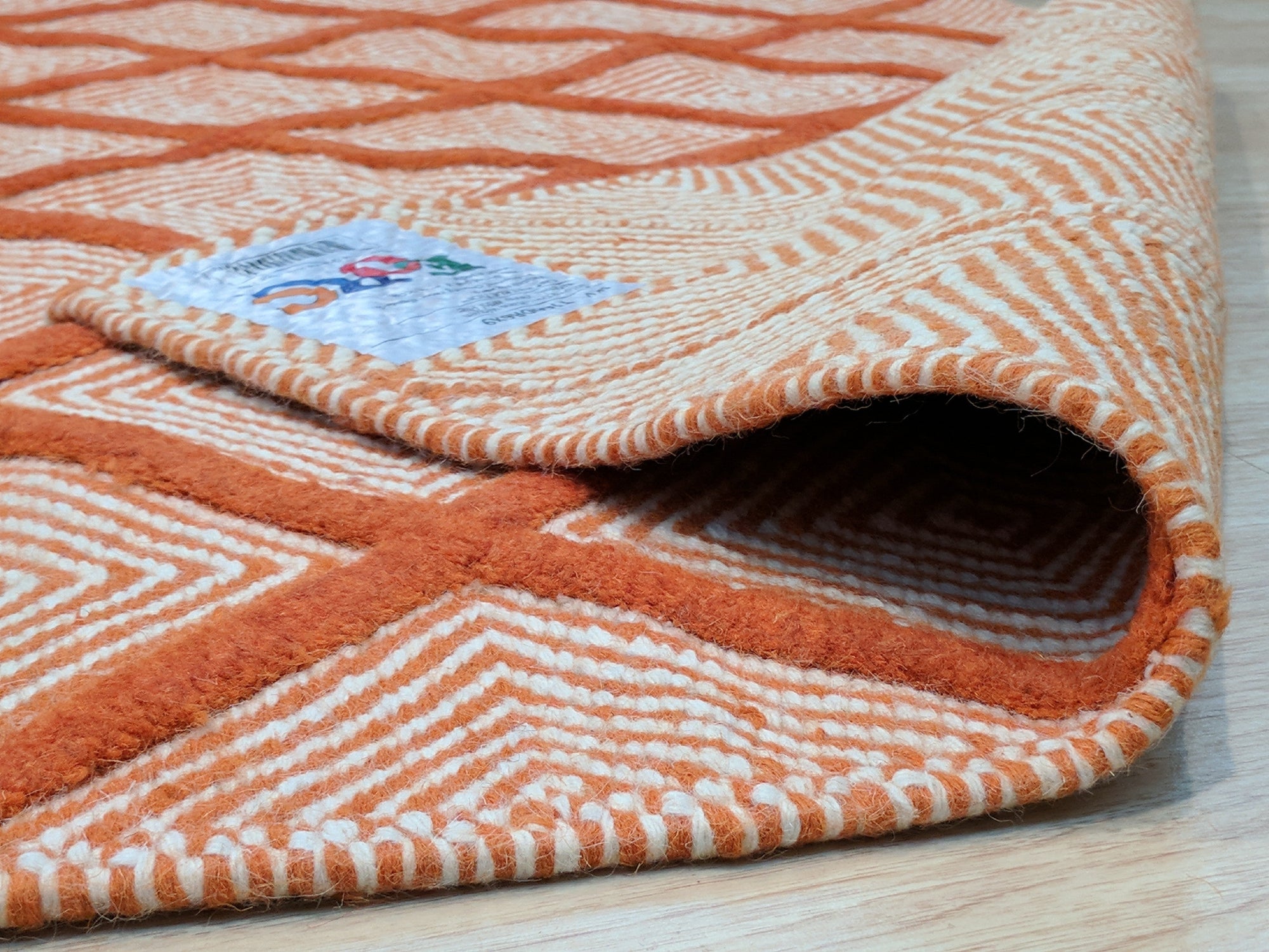 Refined Luxurious Orange Handmade Wool Rug, vibrant orange wool adding warmth to a room with neutral furniture; intricate, possibly hand-knotted construction visible in detail.