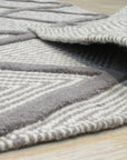 Trendy Diamond Gray Hand Knotted Wool Rug, its geometric diamond pattern subtly textured and displayed on a hardwood floor in a living room setting.