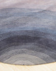 Xena Violet Blue Hand Tufted Wool Rug, a vibrant blend of violet and blue hues in a hand-tufted wool construction, displayed in a stylish home setting.
