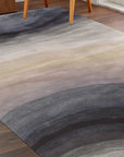 Xena Violet Blue Hand Tufted Wool Rug, blends violet and blue hues in a hand-tufted wool construction, creating a sophisticated and textured floor covering in a styled room setting.