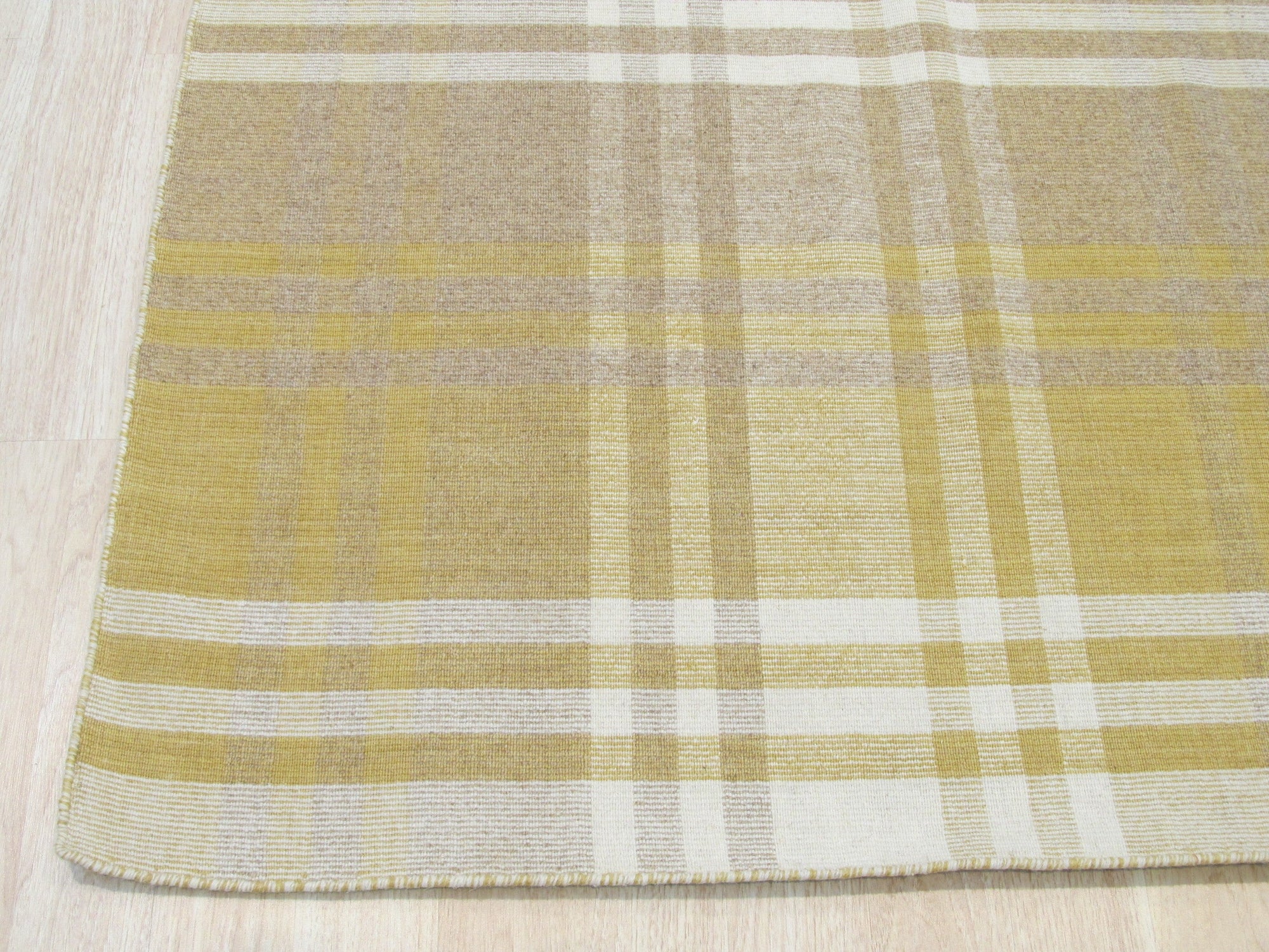 Chic Serene Yellow Flatweave Wool Rug, its soft yellow tones and flatweave construction complementing a bright, modern living room scene.