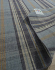 Jade Dahlia Blue Flatweave Wool Rug, a vibrant geometric design in shades of blue and ivory, lies centered on a polished concrete floor, showcasing its flatweave construction and cool-toned palette within a modern living space.