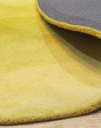 Inviting Ruby Yellow Hand Tufted Wool Rug, featuring swirling patterns in shades of ruby red and golden yellow, covers the floor, adding warmth and texture to a modern living space.