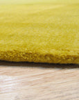 Inviting Ruby Yellow Hand Tufted Wool Rug, its warm ruby and yellow hues radiating from a densely tufted wool pile, sits elegantly on a light hardwood floor.