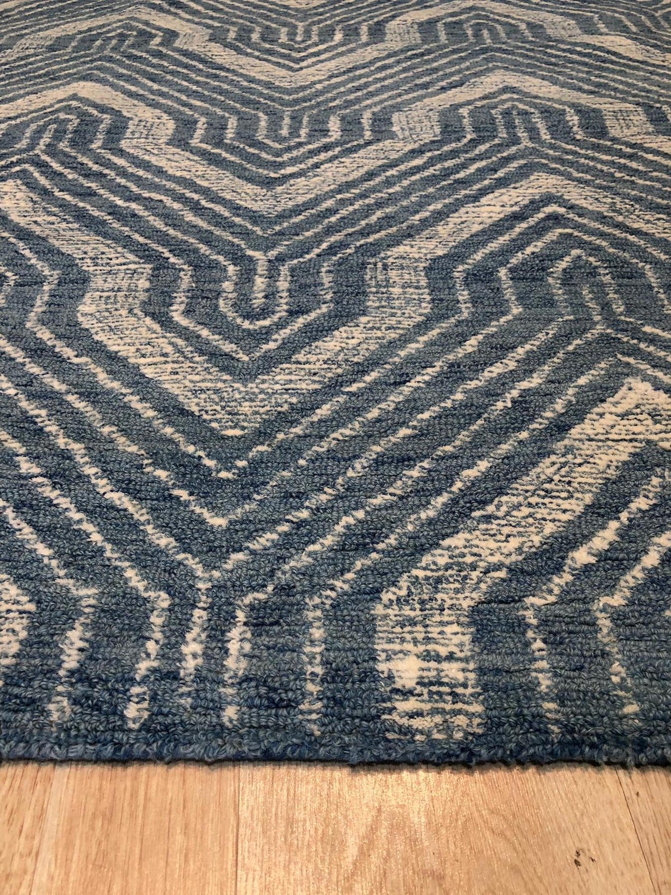 Lila Dahlia Blue Hand Tufted Wool Rug, its dahlia-inspired floral design blooming in shades of blue across a soft, hand-tufted wool canvas.