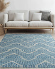 Lila Dahlia Blue Hand Tufted Wool Rug, displaying intricate floral patterns in shades of blue and ivory, lies elegantly in a bright, modern living room setting.