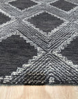 Xena Ava Charcoal Hand Tufted Wool Rug, hand-tufted wool construction with a deep charcoal hue, displayed in a bright, modern living room setting with minimalist decor.