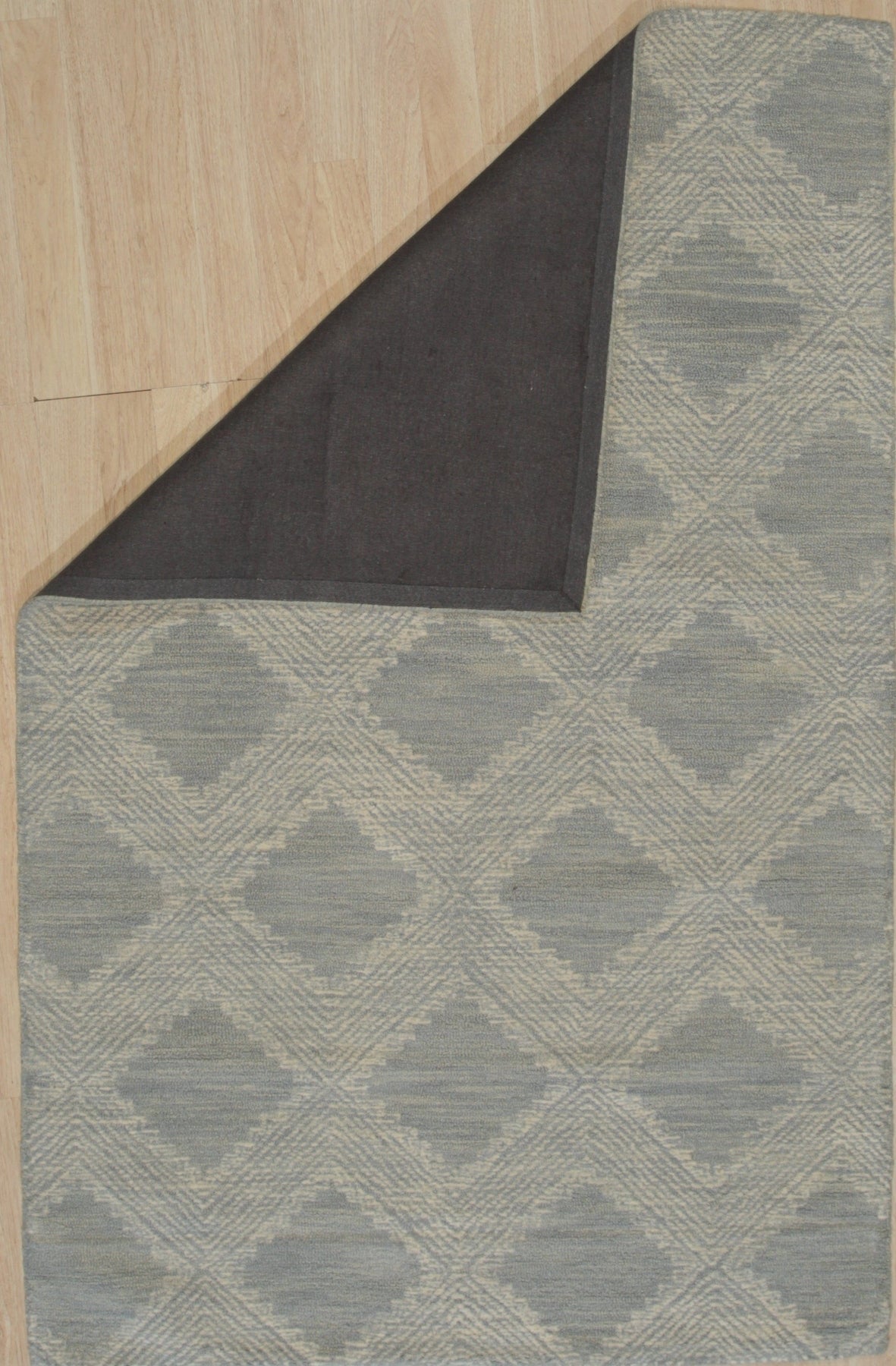 Chloe Quinn Light Blue Hand Tufted Wool Rug, a calming blend of light blues and subtle patterns, graces a bright living space with its plush, hand-tufted texture.