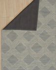 Chloe Quinn Light Blue Hand Tufted Wool Rug, a calming blend of light blues and subtle patterns, graces a bright living space with its plush, hand-tufted texture.