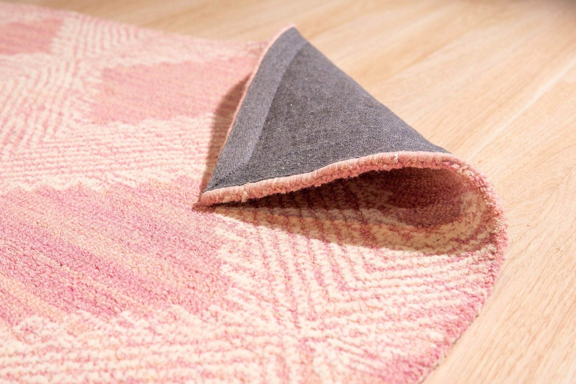 Unique Sloane Pink Hand Tufted Wool Rug, a soft pink wool rug with subtle geometric patterning, subtly textured and adding warmth to a bright living space.