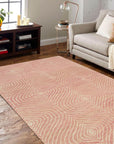 Talia Artistic Pink Hand Tufted Wool Rug, soft pink and cream hues swirling in an abstract design, covering a living room floor with plush texture and warmth.