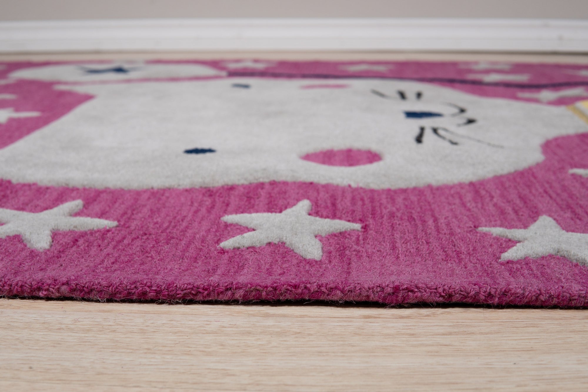 Iris Laine Pink Hand Tufted Wool Rug, its plush wool pile bathed in soft pink hues, lends a touch of warmth to a neutral-toned living space.