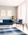 Sophisticated Elegant Blue Flatweave Wool Rug, showcasing a serene living room scene. Light wood floors complement the rug's cool blue tones and subtle geometric pattern. The flatweave wool texture adds a layer of understated elegance to the space.
