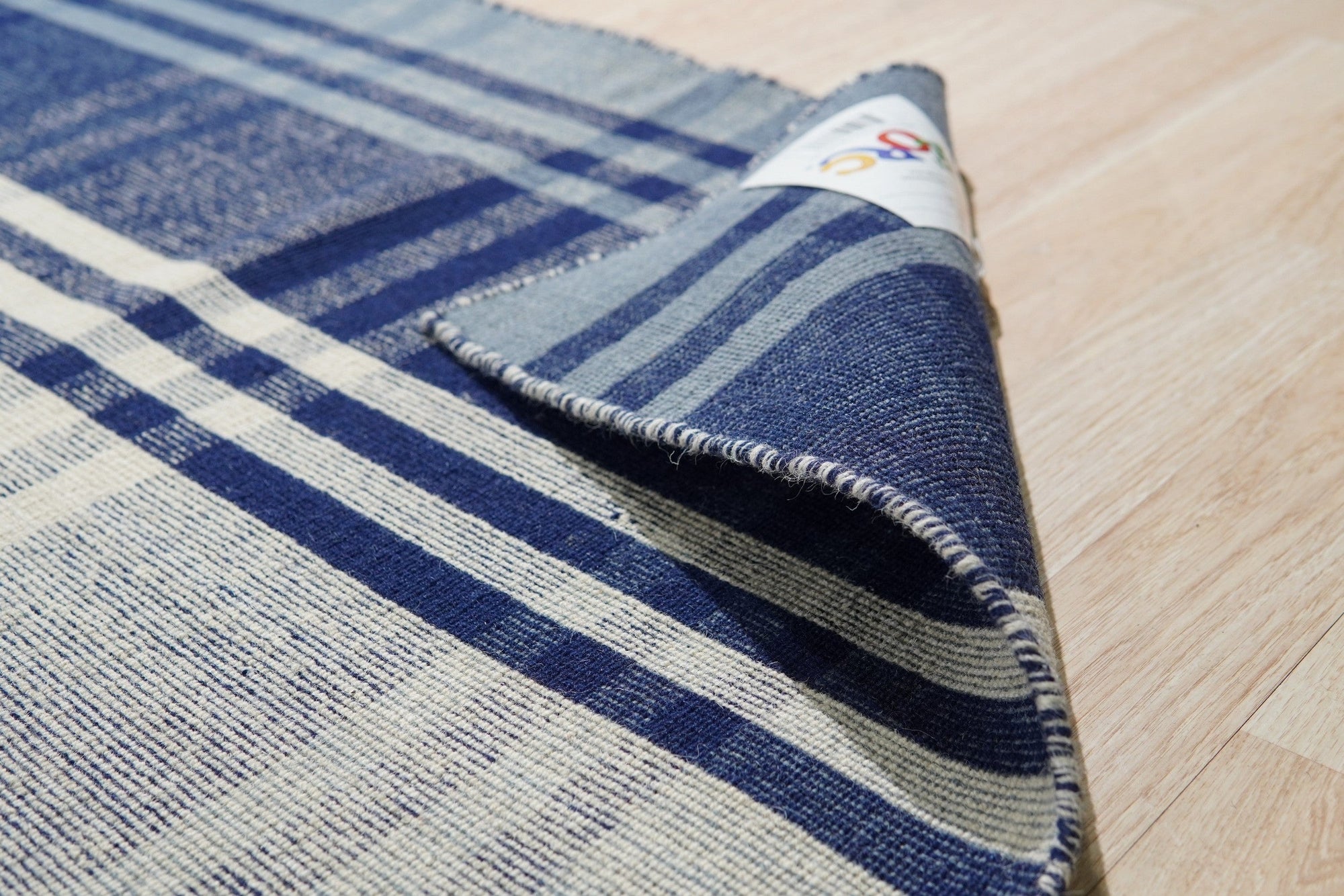 Sophisticated Elegant Blue Flatweave Wool Rug, a calming expanse of blue woven wool, rests on light hardwood floors, its flatweave construction lending a subtle texture to the room.