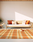 Cassandra Stylish Orange Flatweave Wool Rug, seen in a living room setting; its vibrant orange hues and flatweave construction bring warmth to the neutral decor, creating a stylish and inviting space.