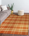 Cassandra Stylish Orange Flatweave Wool Rug, showcasing a bright, modern living room; the orange wool flatweave rug anchors the space with its subtle texture and vibrant hue, complementing neutral furniture and warm lighting.