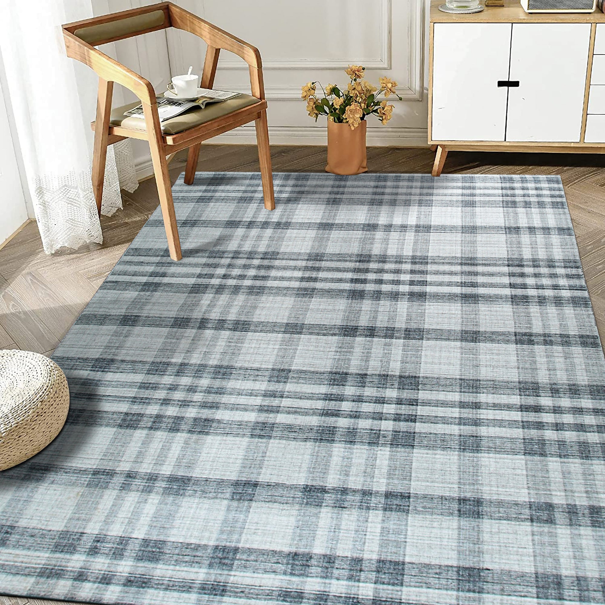 Jasmine Stylish Gray Flatweave Wool Rug displayed in a bright, modern living room setting. Its flatweave construction allows other furniture such as a stylish coffee table and dark-colored couch to effortlessly stand on it.