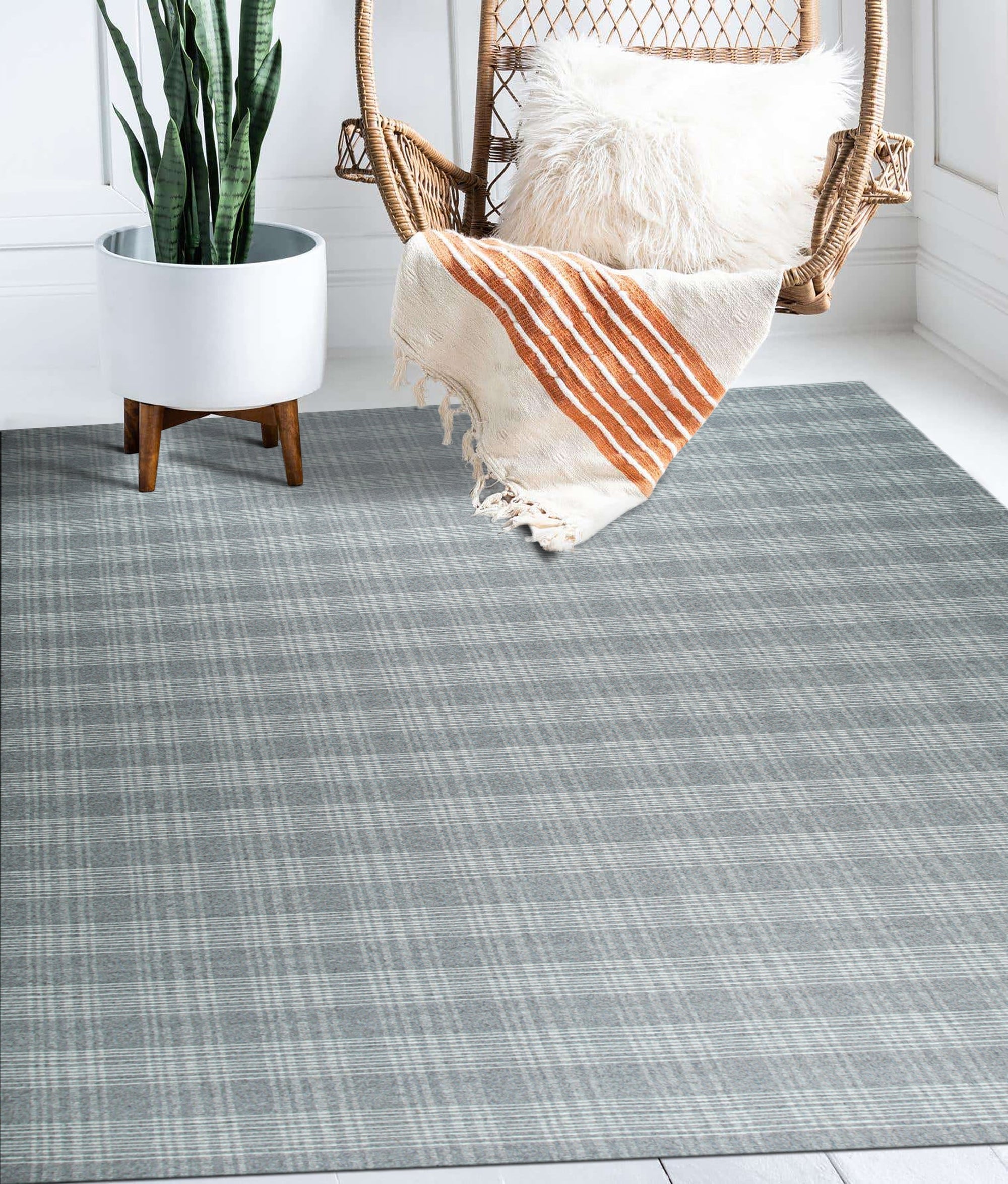 Classic Radiant Gray Flatweave Wool Rug, its subtle gray tones and flatweave texture complementing a bright, modern living room with a white sofa and light wood coffee table.