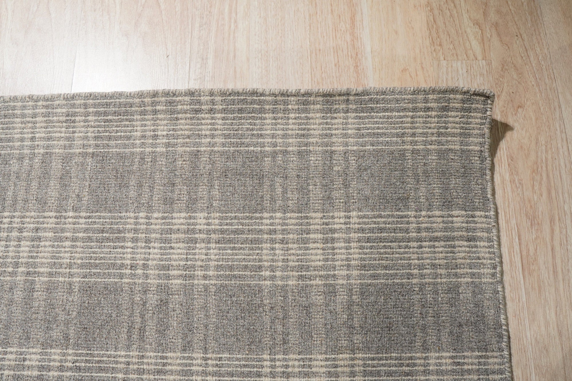 Classic Radiant Gray Flatweave Wool Rug in a bright living room; soft light illuminates the rug's subtle gray tones and flatweave texture beneath a modern coffee table.