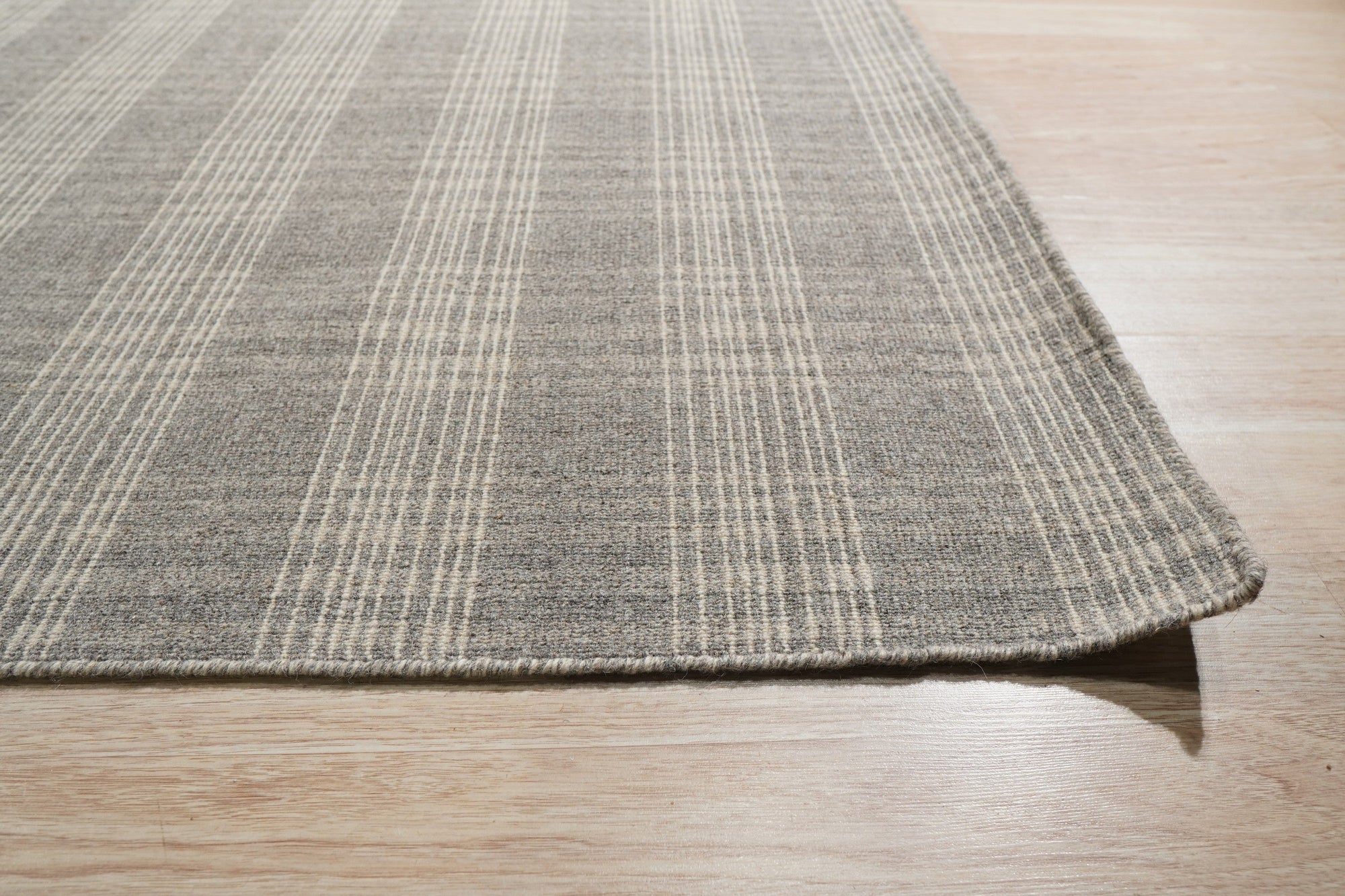 Classic Radiant Gray Flatweave Wool Rug displayed in a living room setting; its flatweave construction showcases subtle gray variations, complementing the modern furniture.