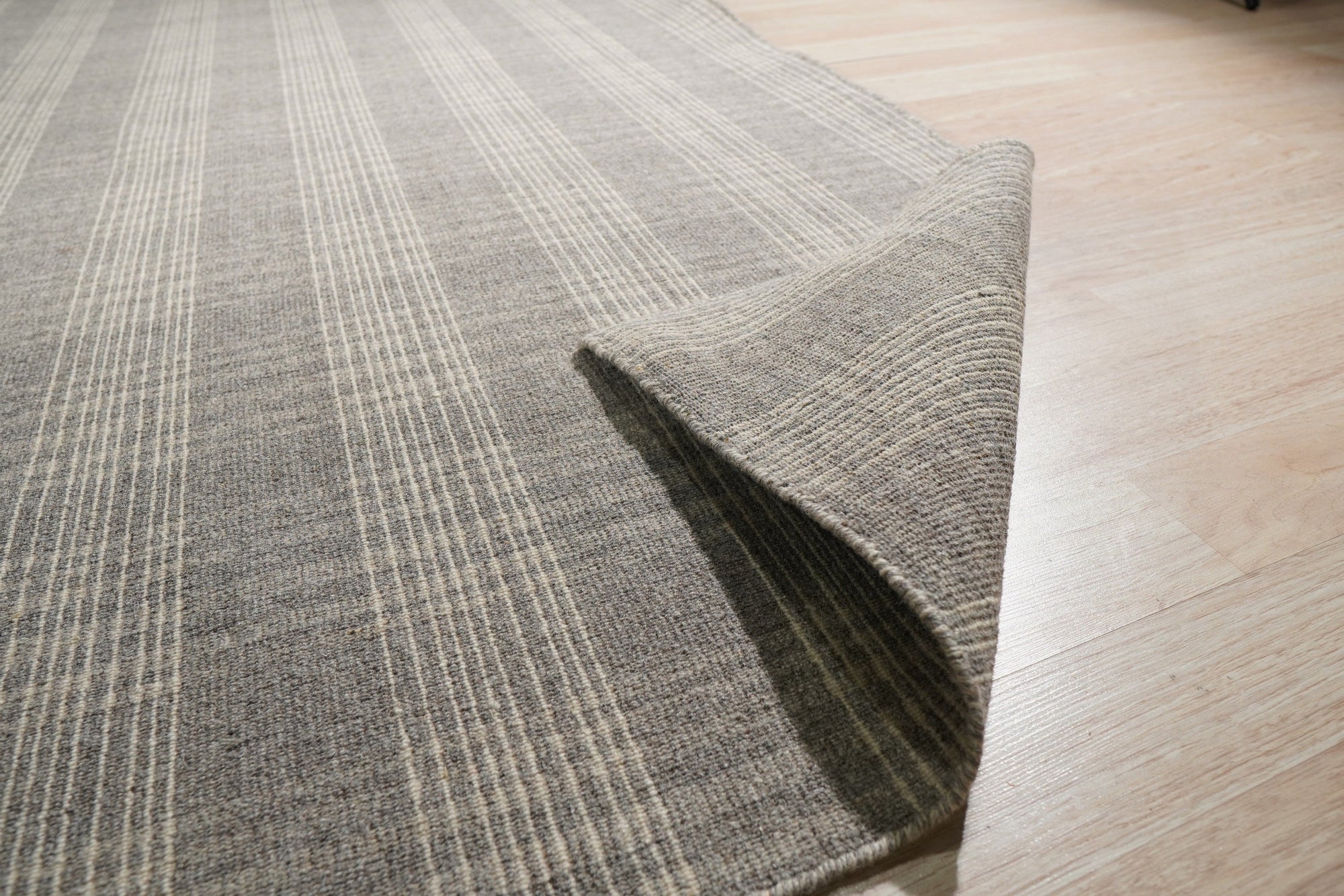 Classic Radiant Gray Flatweave Wool Rug, its subtle gray tones and flatweave construction lending understated elegance to a light-filled living space.