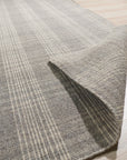 Classic Radiant Gray Flatweave Wool Rug graces a warmly lit living room; soft gray wool, flatweave construction visible, anchors a seating area with modern furniture.